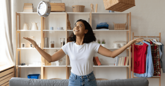 Une femme accrochant une pelle sur un rangement mural fait avec une palette.