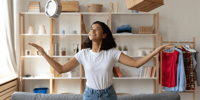 Une femme accrochant une pelle sur un rangement mural fait avec une palette.