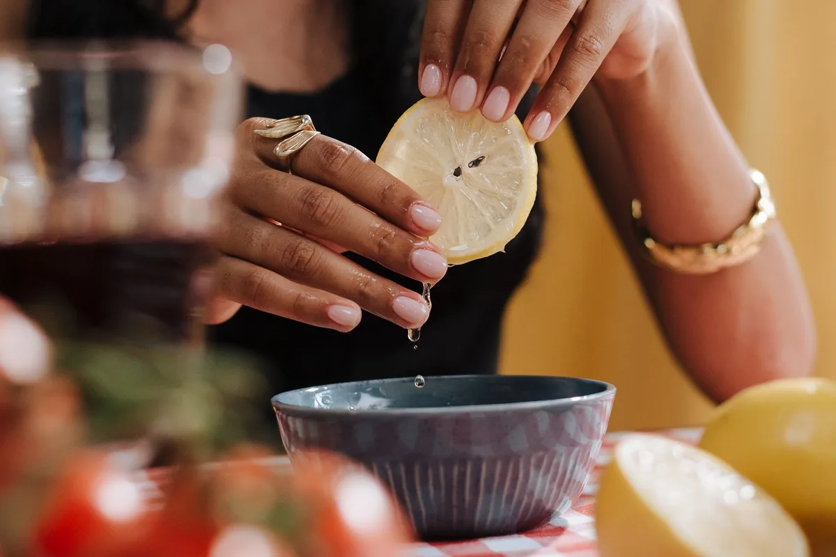 Citron frais coupé en deux avec du jus s'écoulant, prêt pour un soin des ongles