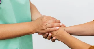 Deux personnes se tenant les mains en signe de soutien et de compassion
