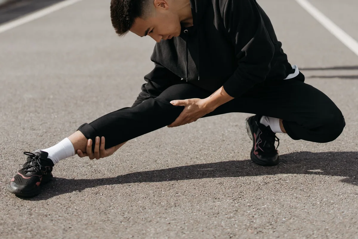 Coureur effectuant des exercices d'échauffement et d'étirement avant une séance de course
