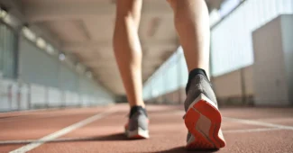 Coureur en chaussure de sport sur piste d'entraînement, montrant l'effort et la charge répétée