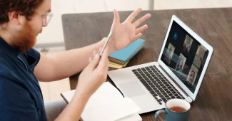 Personne travaillant sur un ordinateur portable lors d'une visioconférence professionnelle depuis un bureau