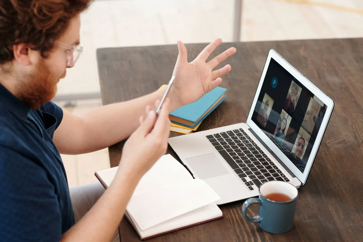 Personne travaillant sur un ordinateur portable lors d'une visioconférence professionnelle depuis un bureau