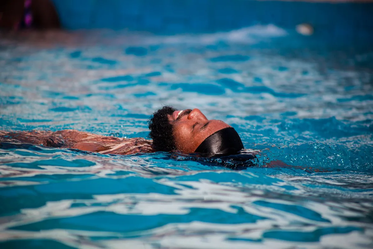 Femme pratiquant la natation en piscine avec des mouvements doux