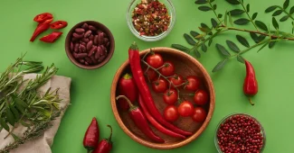 Mains préparant des légumes colorés et des herbes aromatiques sur un plan de travail en bois