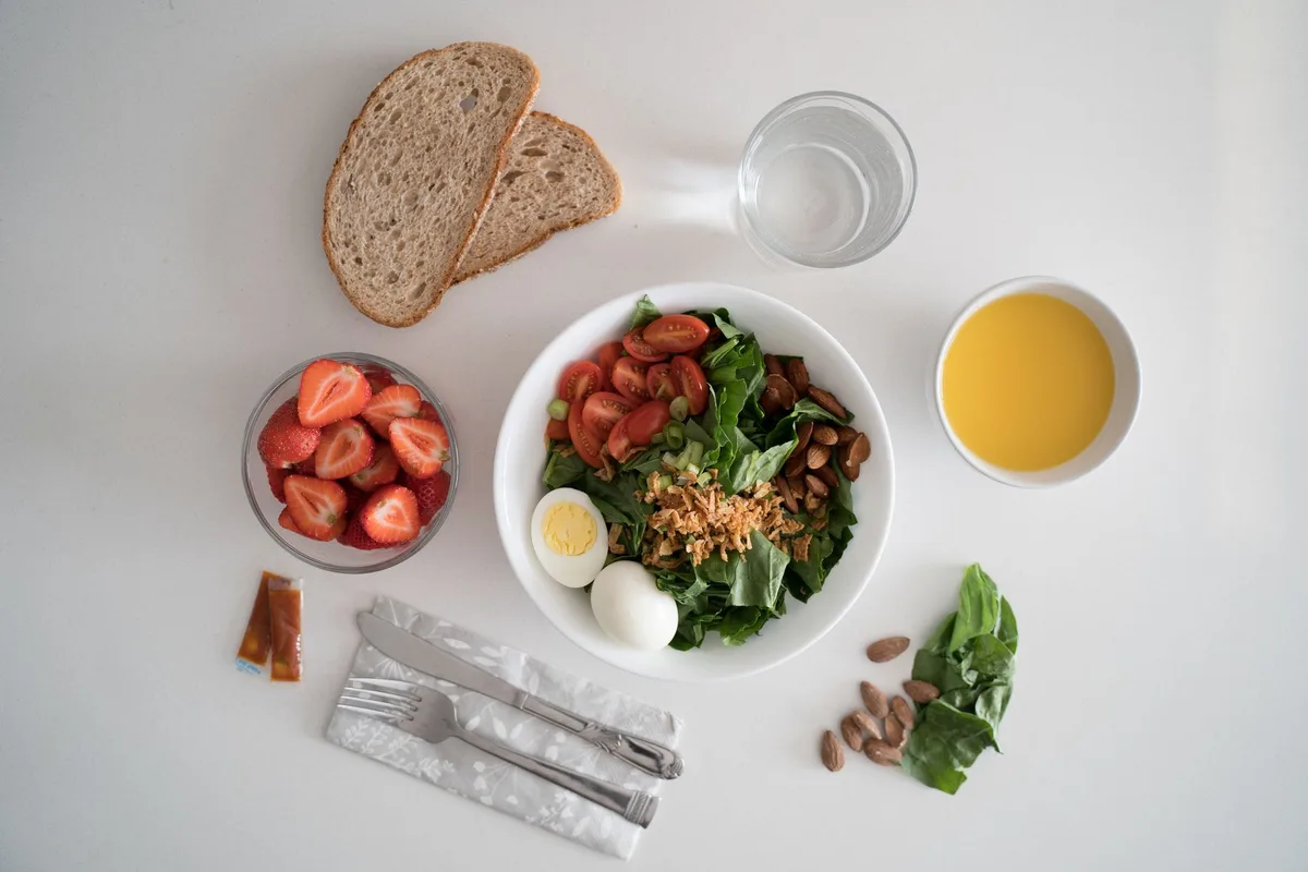 Assiette équilibrée avec légumes frais, fruits et céréales complètes pour une alimentation saine