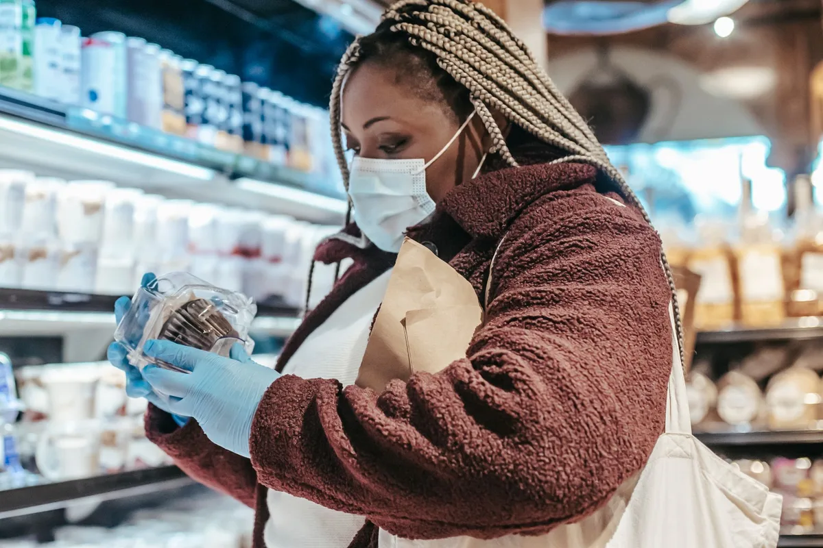 Femme lisant attentivement l'étiquette d'un complément alimentaire