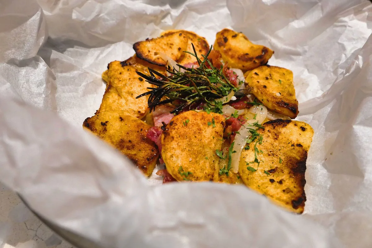 Poisson enveloppé en papillote avec papier sulfurisé et aromates