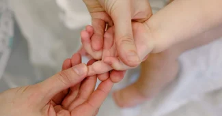 Praticien effectuant un examen ostéopathique doux sur un nourrisson