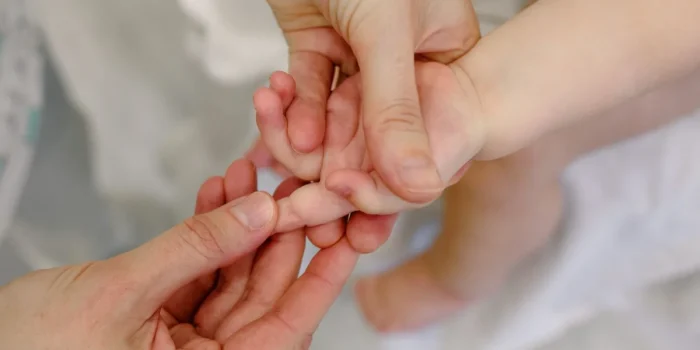 Praticien effectuant un examen ostéopathique doux sur un nourrisson
