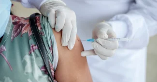 Professionnel de santé effectuant une injection vaccinale chez un jeune patient en milieu clinique