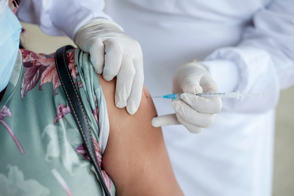 Professionnel de santé effectuant une injection vaccinale chez un jeune patient en milieu clinique