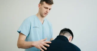 Kinésithérapeute effectuant une thérapie manuelle sur la jambe d'un athlète en séance de rééducation