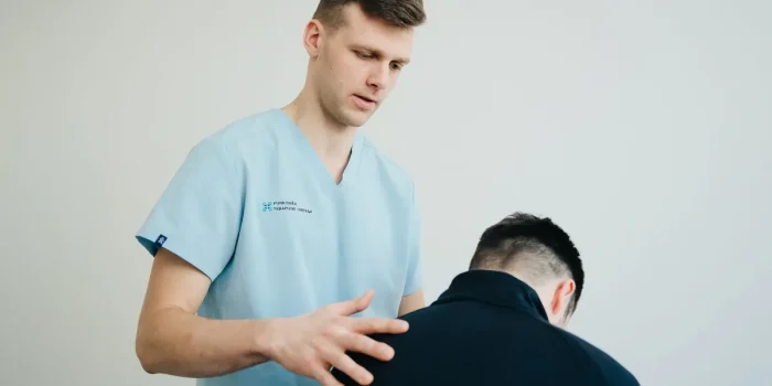 Kinésithérapeute effectuant une thérapie manuelle sur la jambe d'un athlète en séance de rééducation