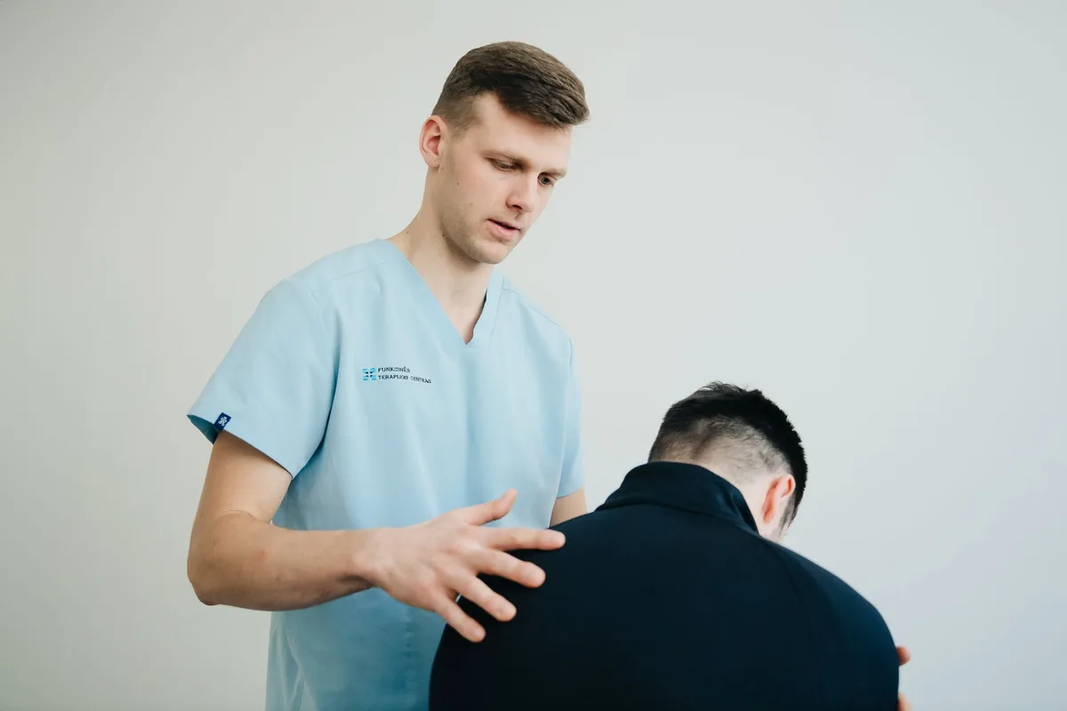 Kinésithérapeute effectuant une thérapie manuelle sur la jambe d'un athlète en séance de rééducation