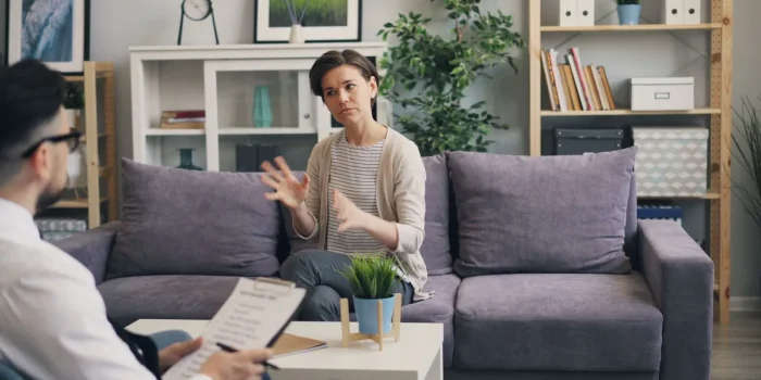 Cabinet de thérapie avec deux personnes en consultation, ambiance calme et bienveillante
