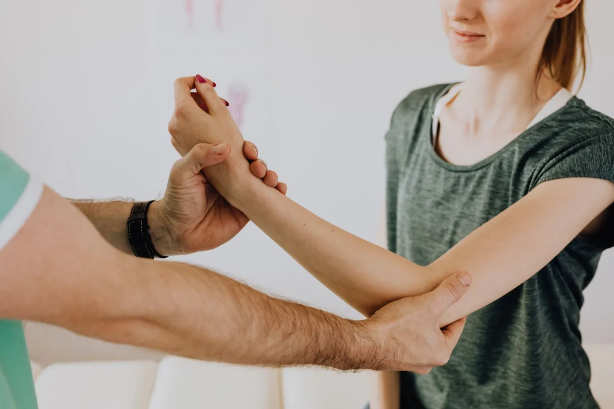 Ostéopathe effectuant une mobilisation articulaire sur le genou d'un patient