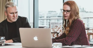Deux professionnels en discussion réfléchie dans un cadre de bureau neutre
