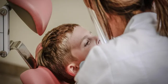 Patient et kiné anonymes réalisant un exercice dans une salle de kiné lumineuse