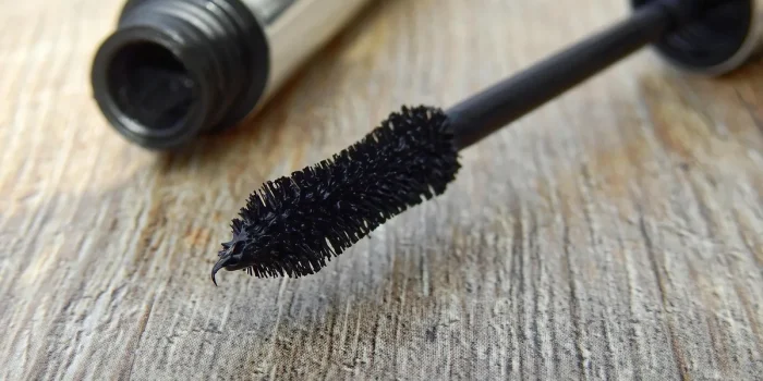 Goupillon et recourbe-cils sur une serviette près d'une fenêtre en journée