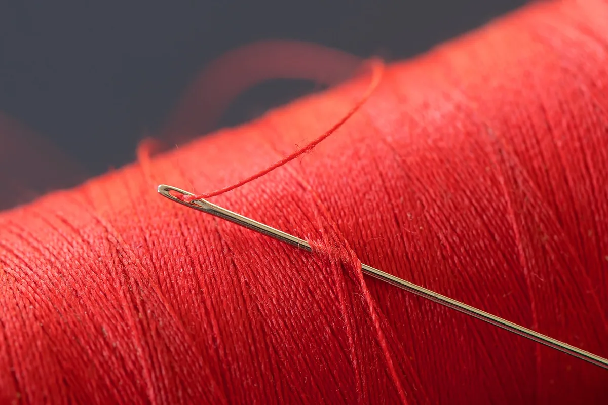 Repli d'ourlet de jean maintenu par des épingles avant couture