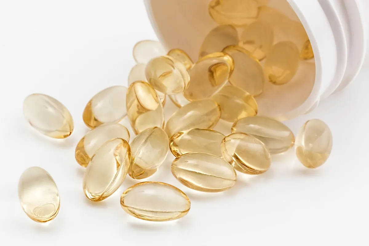 Compléments probiotiques en gélules à côté d'un yaourt, illustrant les sources alimentaires et supplémentation