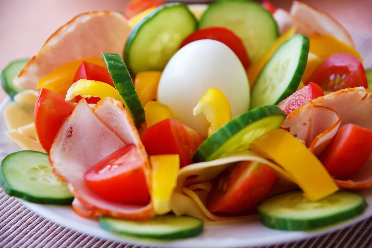 Assiette variée avec poissons gras, œufs, légumes verts et fruits à coque