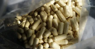 Comprimé de zinc ou poudre minérale avec verre d'eau en arrière-plan