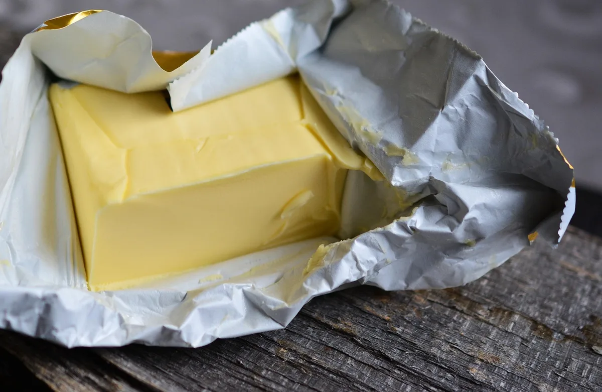 Main vérifiant un paquet alimentaire ouvert sur une étagère du placard