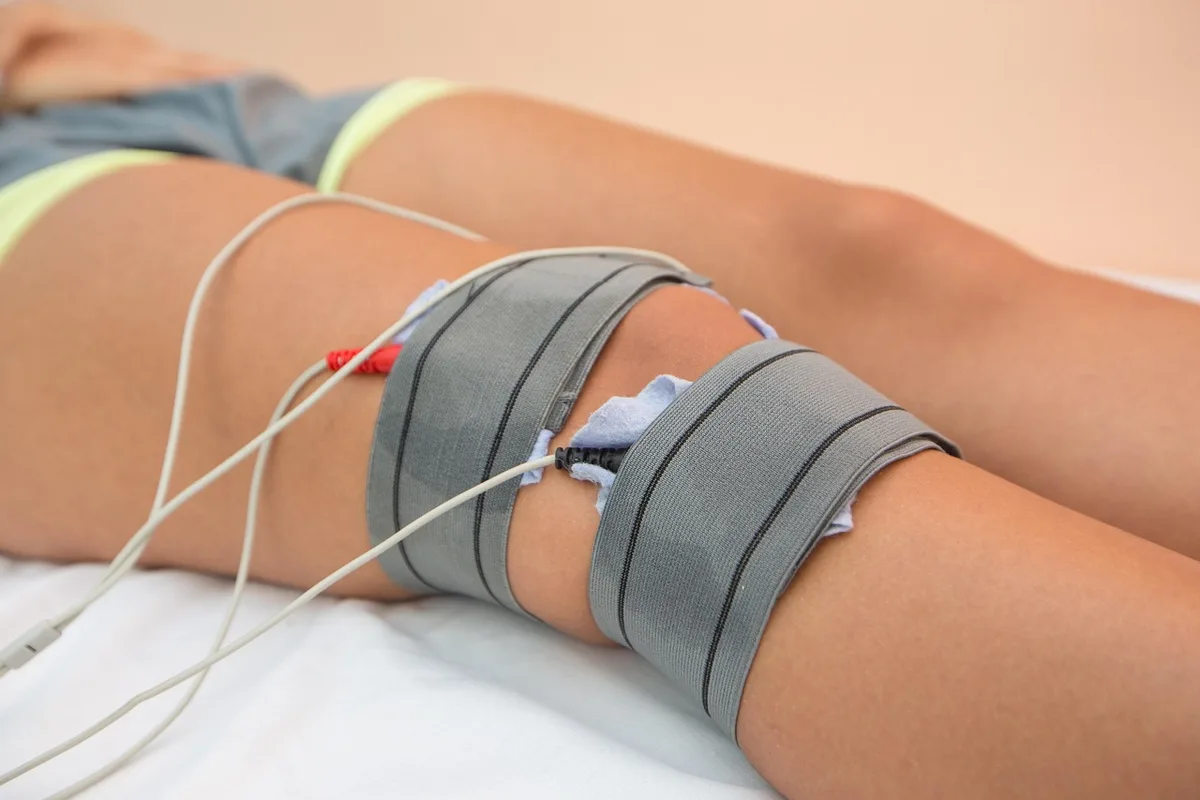 Patient de dos discutant de douleurs du genou avec un médecin dans une salle de consultation