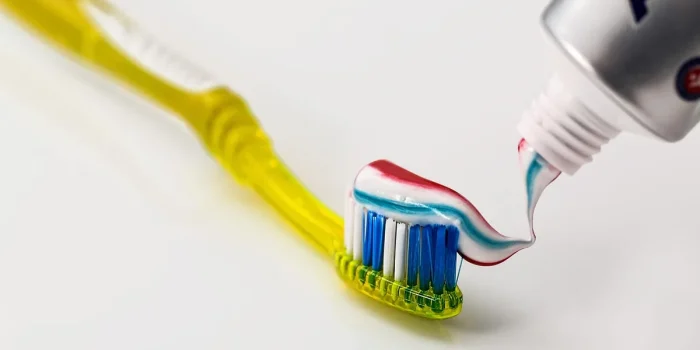 Mains massant une cheville posée sur un coussin près d'une fenêtre lumineuse