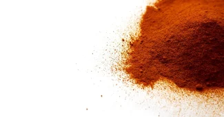 Mortier et poudre de curcuma sur une table de cuisine éclairée par la lumière du jour