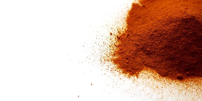 Mortier et poudre de curcuma sur une table de cuisine éclairée par la lumière du jour