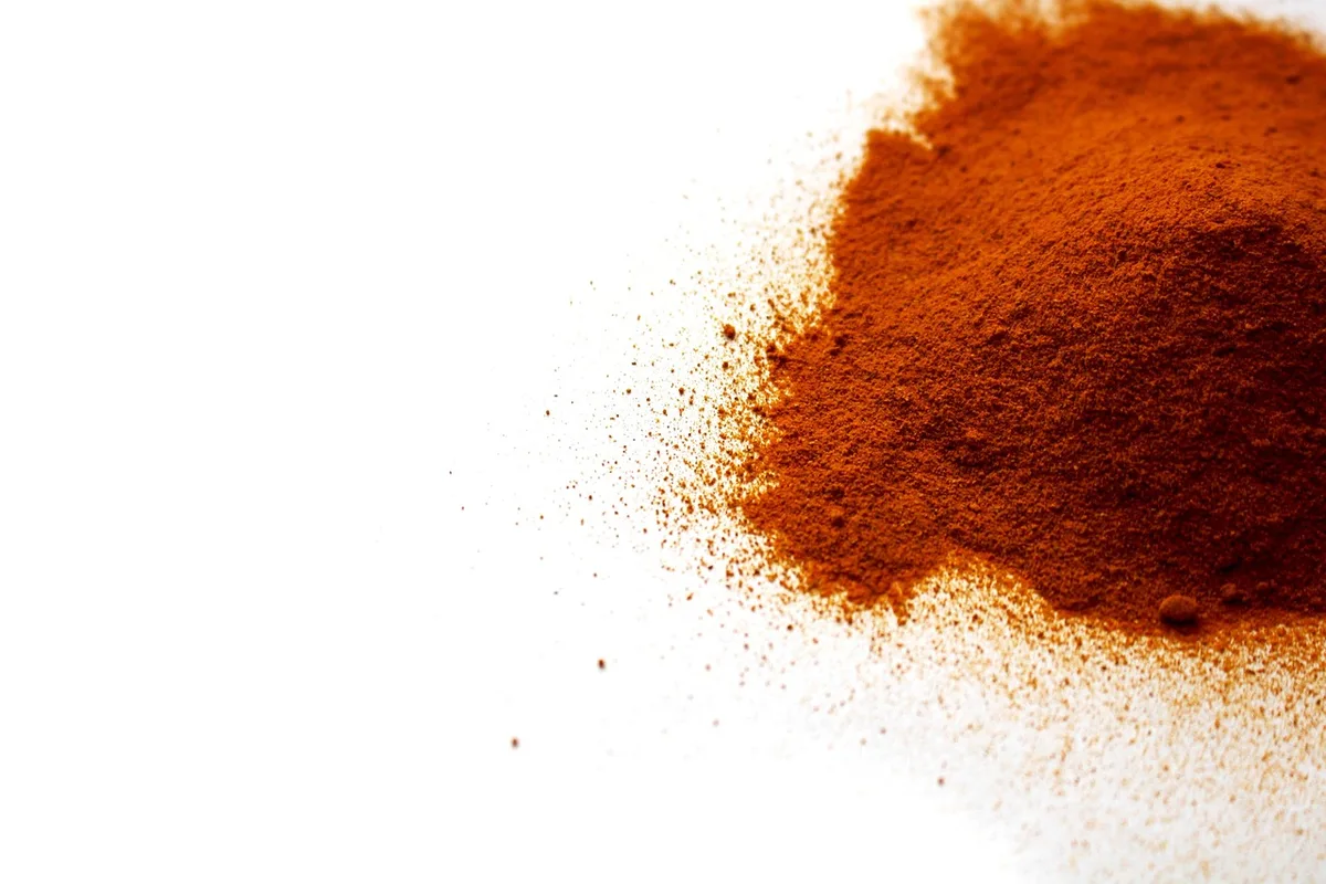 Mortier et poudre de curcuma sur une table de cuisine éclairée par la lumière du jour
