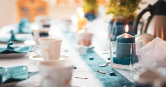 Table dressée en journée avec serviettes pliées élégantes et mains ajustant un anneau