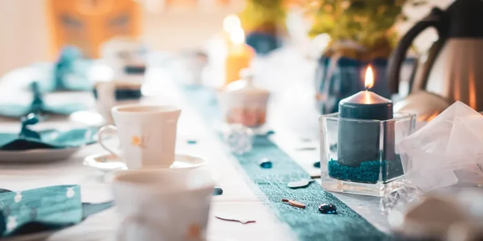 Table dressée en journée avec serviettes pliées élégantes et mains ajustant un anneau