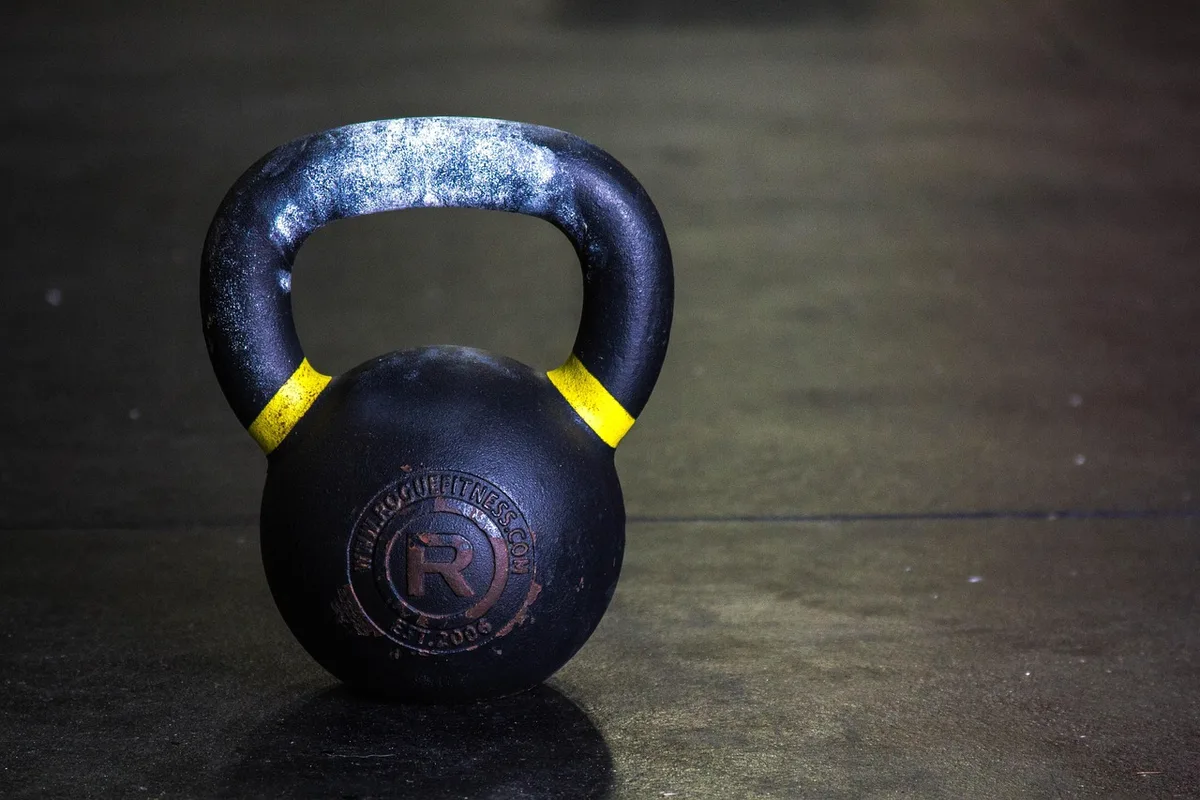 Shaker protéiné posé à côté d'une serviette et d'haltères pour symboliser le soutien musculaire
