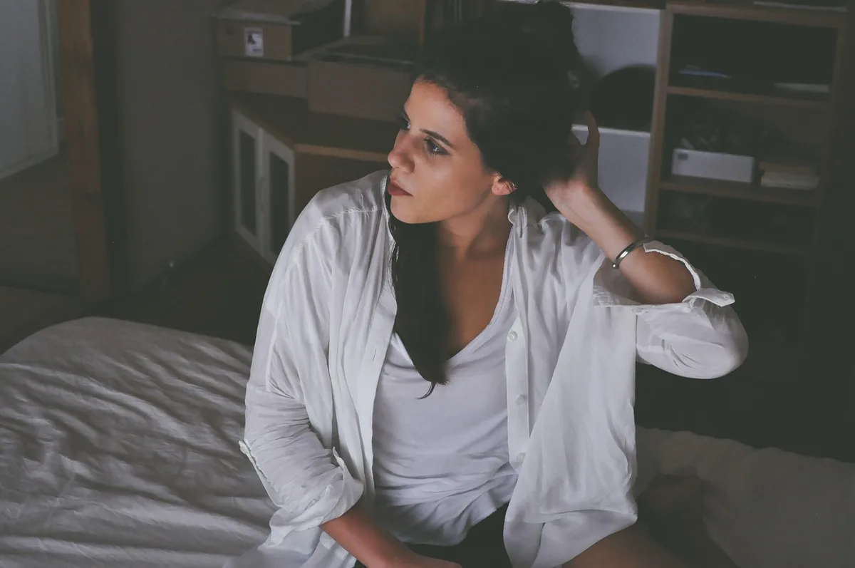 Personne se réveillant et se massant la nuque au lit