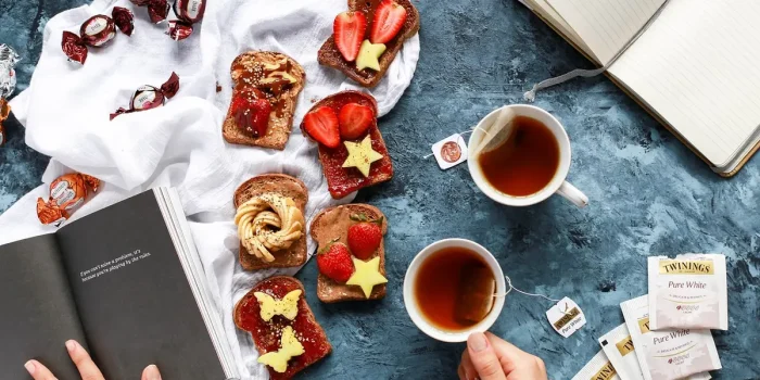 Table de petit-déjeuner ensoleillée avec eau, tisane et carnet