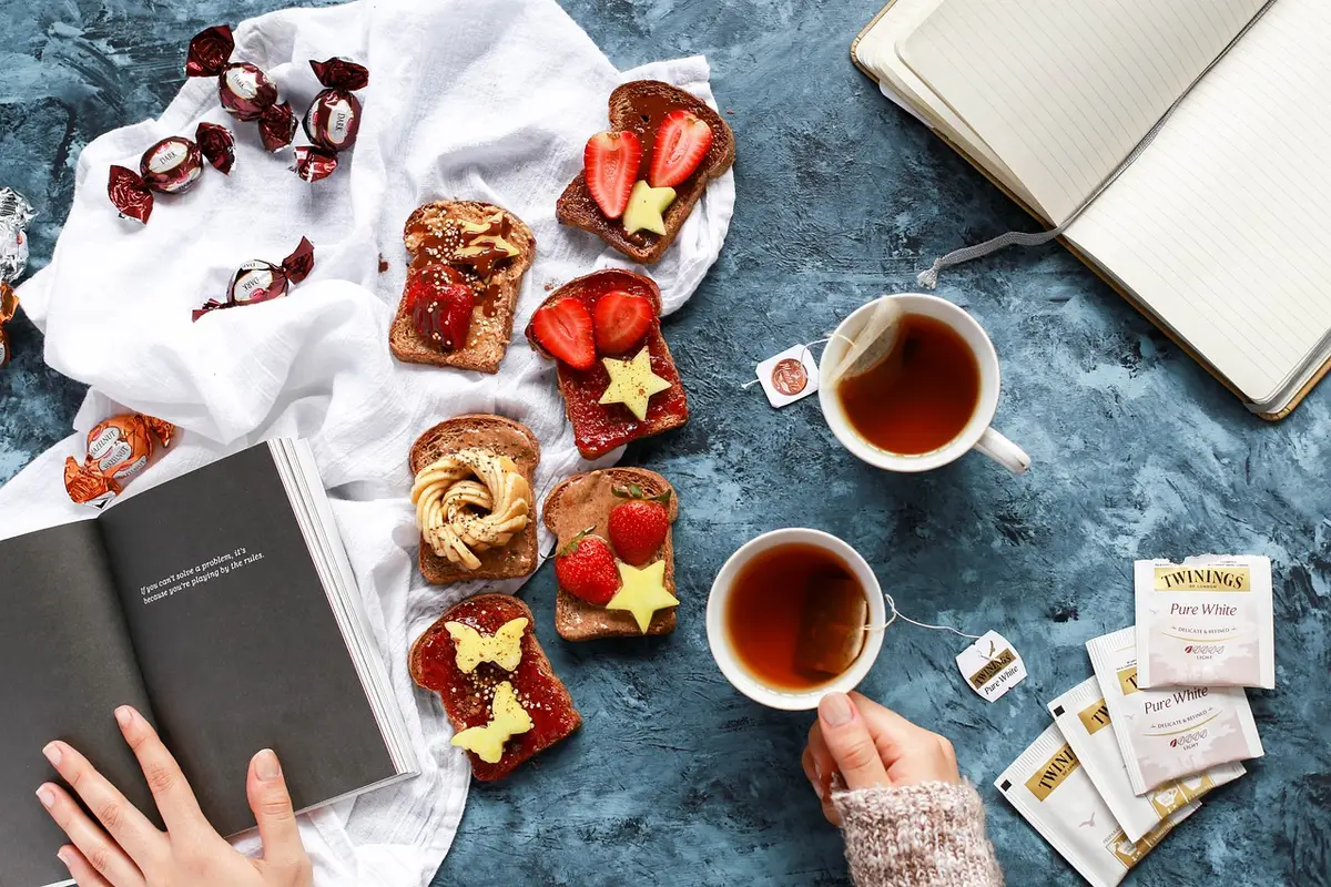 Table de petit-déjeuner ensoleillée avec eau, tisane et carnet